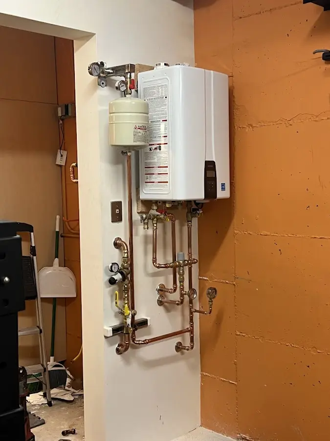 Plumbing technician inspecting water heater connections in Cave Springs